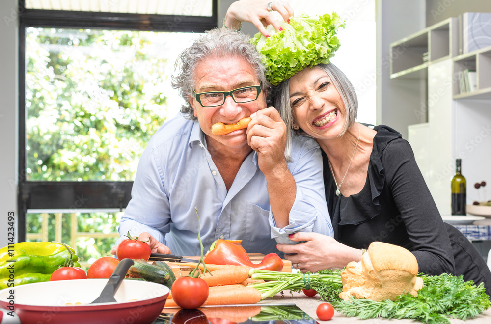 Senior couple having fun in kitchen with healthy food - Retired poeple cooking together vegetarian gourmet plate at home Senior couple having fun in kitchen with healthy food - Retired poeple cooking together vegetarian gourmet plate at home