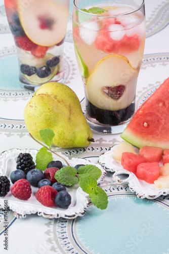 Foto Ingredients and glasses of berries and fruit, mint infused water