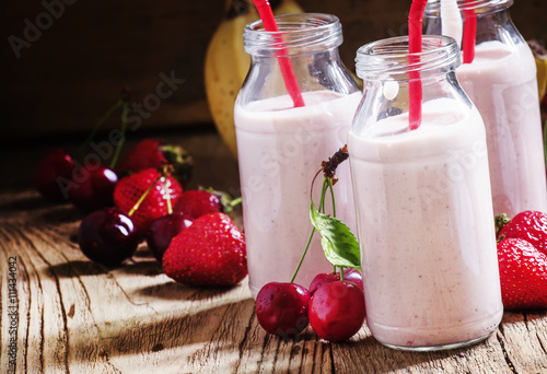 Strawberry Banana smoothie with cherry in glass bottles, vintage