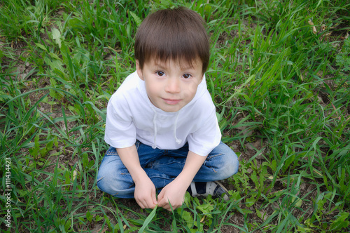 Boy sitting on the grass outside