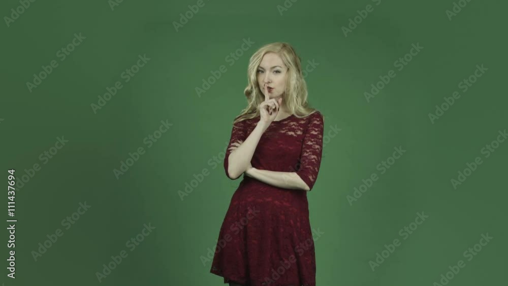 caucasian woman in red dress isolated on chroma green screen background with secret caucasian woman in red dress isolated on chroma green screen background with secret