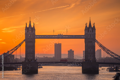 London, England - The iconic Tower Bridge at dawn with flying doves and orange sky 