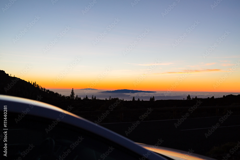 Looking at inspirational landscape ocean view from a car. Mountains and forest silhouette.