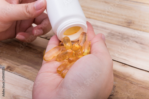Omega 3 fish oil capsule hold by a hand