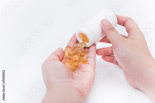 Omega 3 fish oil capsule hold by a hand