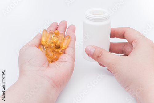 Omega 3 fish oil capsule hold by a hand