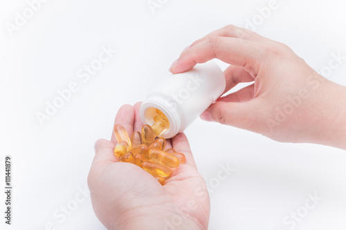 Omega 3 fish oil capsule hold by a hand