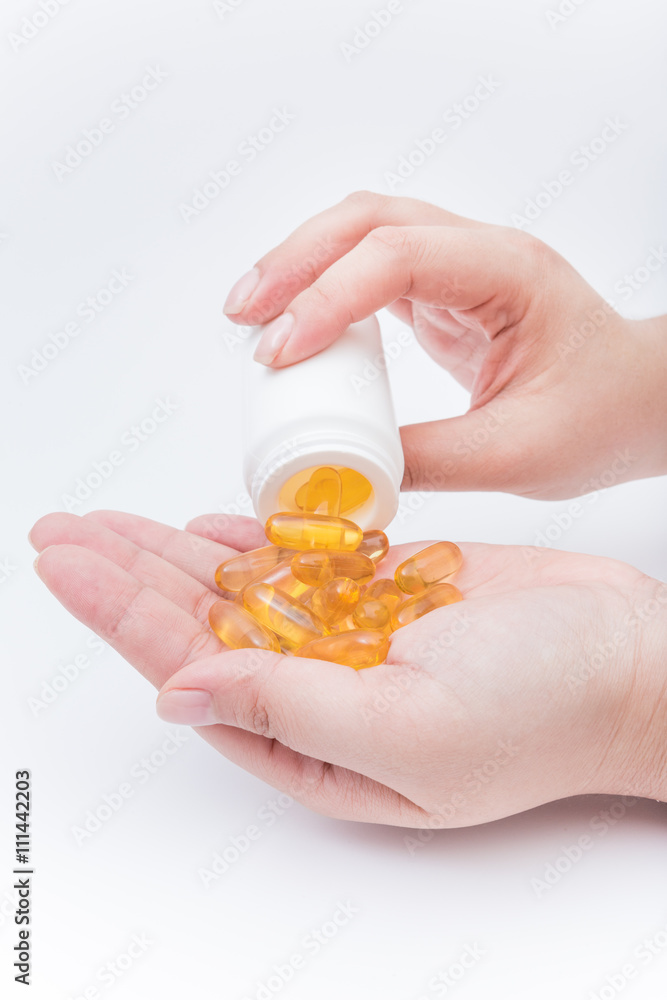 Omega 3 fish oil capsule hold by a hand Omega 3 fish oil capsule hold by a hand
