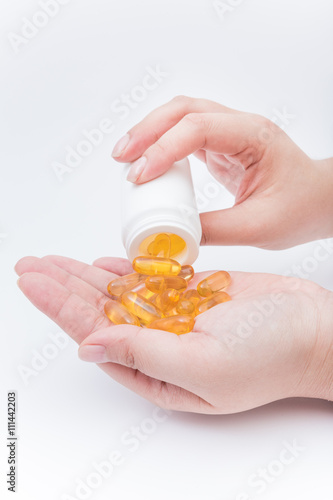 Omega 3 fish oil capsule hold by a hand