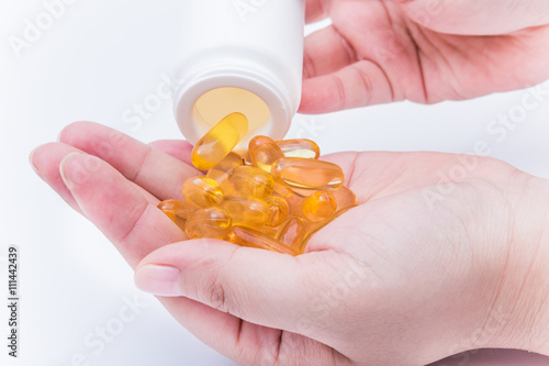 Omega 3 fish oil capsule hold by a hand