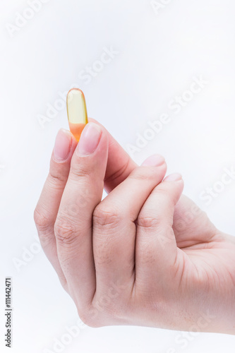 Omega 3 fish oil capsule hold by a hand