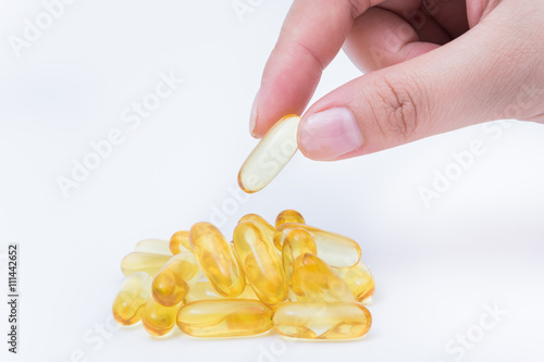 Omega 3 fish oil capsule hold by a hand