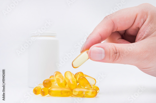 Omega 3 fish oil capsule hold by a hand