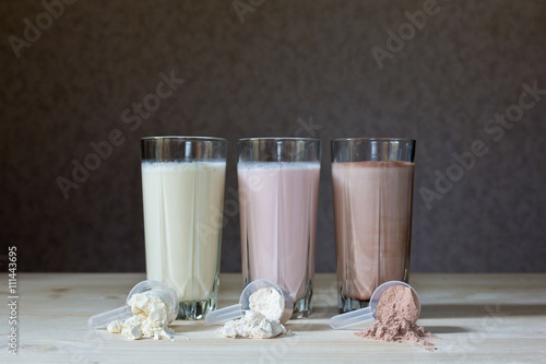 Stampa su tela Three rest milk, chocolate, blueberry and banana drinks on table