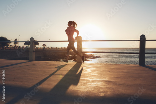 Young woman running on seaside promenade