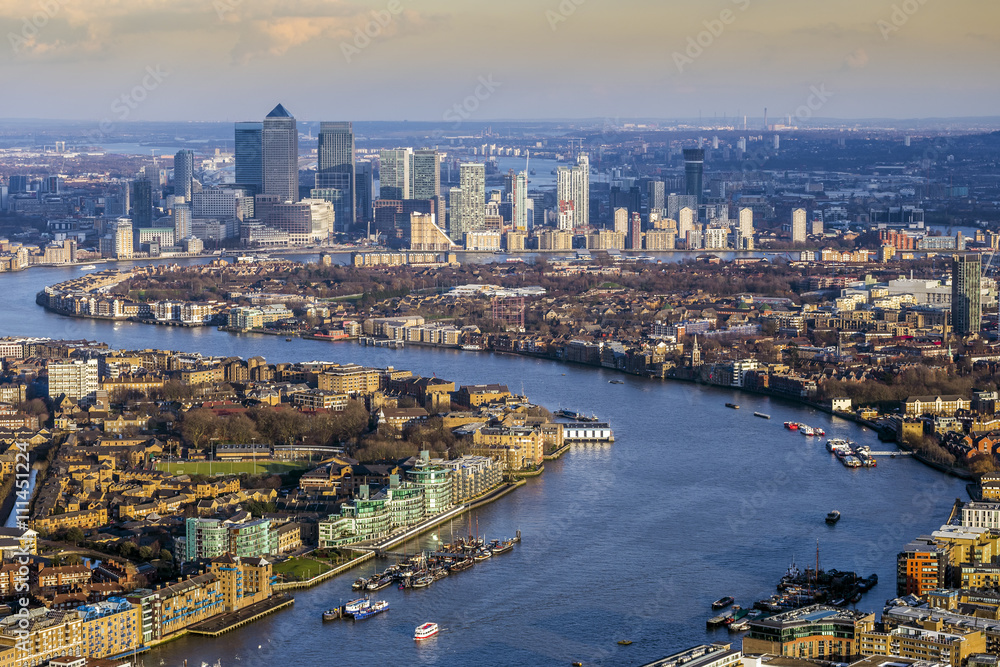 London, England - Aerial skyline view of east London with River Thames and the skyscrapers of Canary Wharf at background