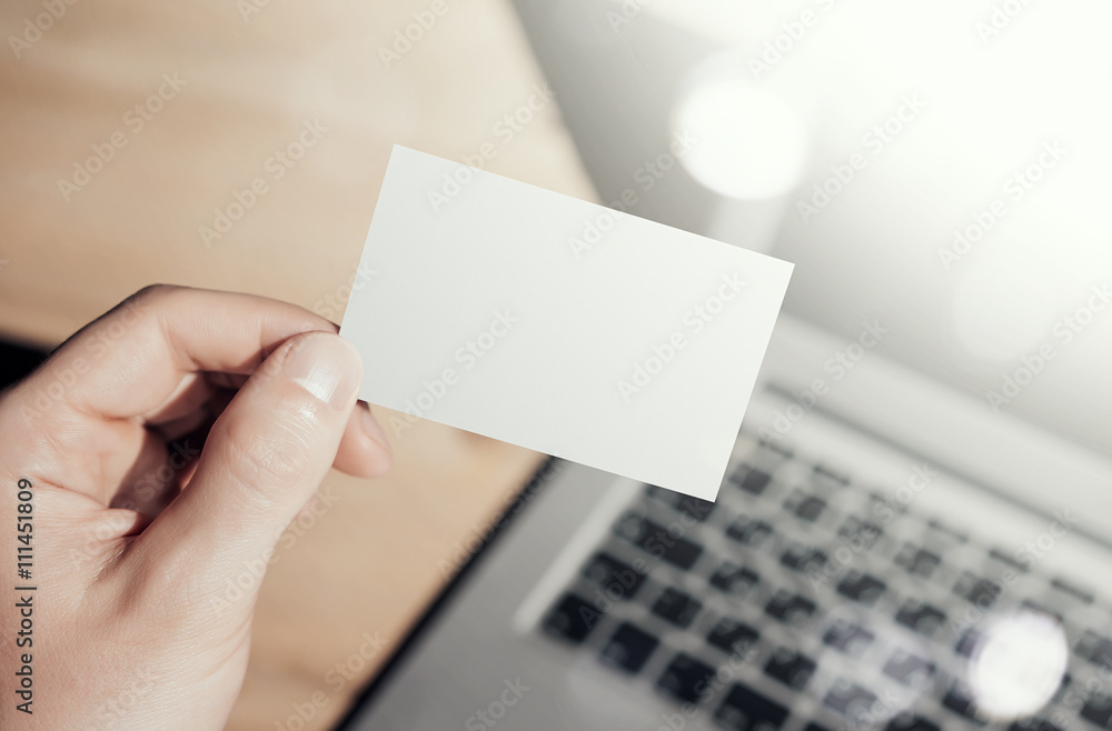 Closeup Photo Man Showing Blank White Business Card and Using Modern Laptop.Wood table Blurred Background. Mockup Ready for Private Information.Sunlight Reflections Screen Gadget. Horizontal mock up. Closeup Photo Man Showing Blank White Business Card and Using Modern Laptop.Wood table Blurred Background. Mockup Ready for Private Information.Sunlight Reflections Screen Gadget. Horizontal mock up.