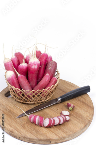 Sliced fresh radishes with knife on the wooden board