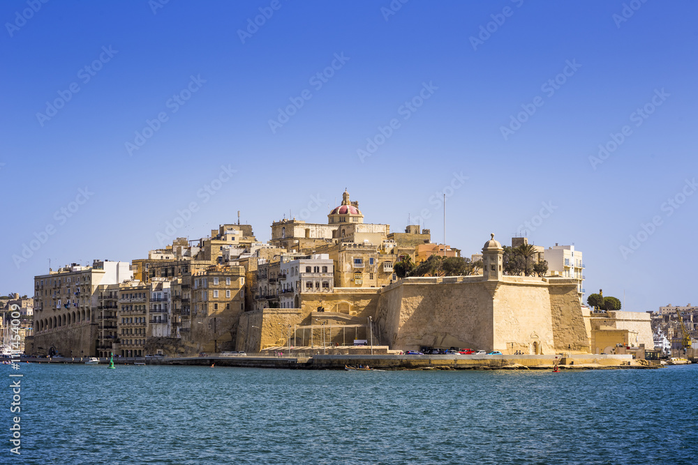 Malta - The ancient walls of Senglea and Gardjola Gardens shot from Valletta on a sunny day with clear blue sky