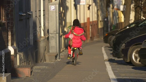 Wallpaper Mural Girl is Riding the Bicycle Down by City Street Opole Poland City Day Child is Riding Among the People Walking by a Street Sunny Day Spring Time Torontodigital.ca
