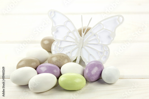 Colored sugared almonds and papery butterfly