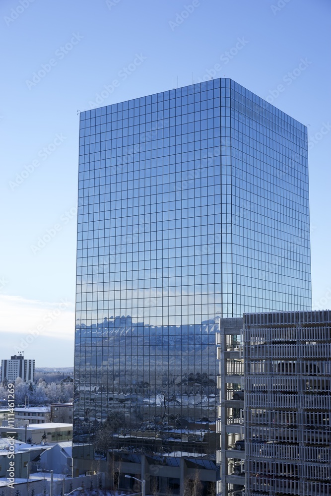 Glass building with mountains reflecting off building.