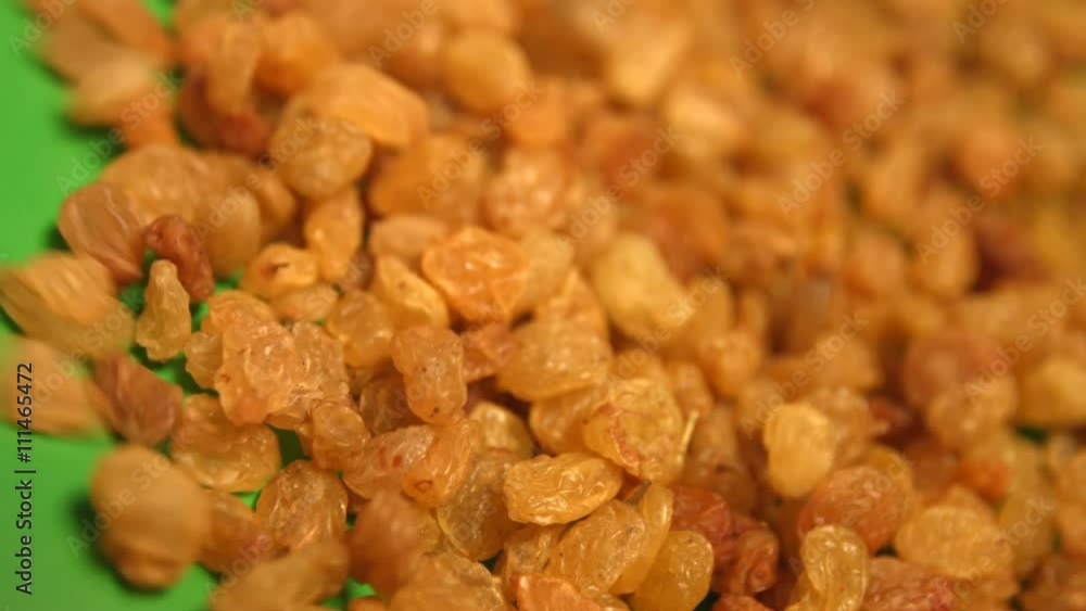 Raisins on a green background. 2 Shots. Horizontal pan. Close-up. Raisins on a green background. 2 Shots. Horizontal pan. Close-up.