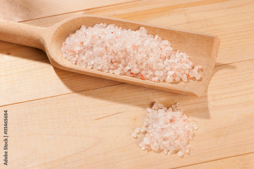wooden spoon full of stone salt on a table wooden spoon full of stone salt on a table