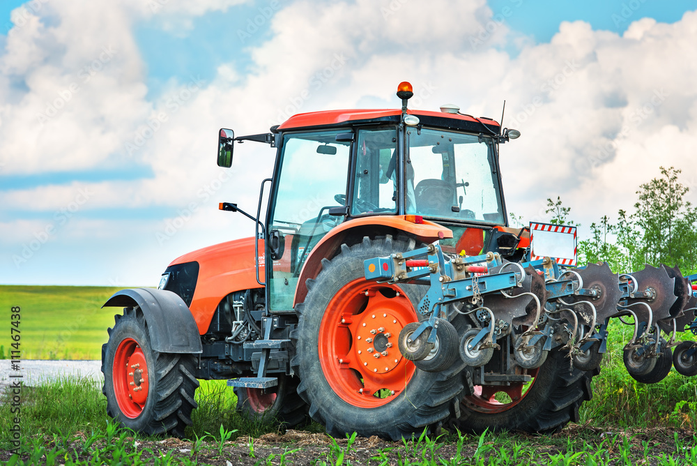 Modern red tractor on the agricultural field. Modern red tractor on the agricultural field.