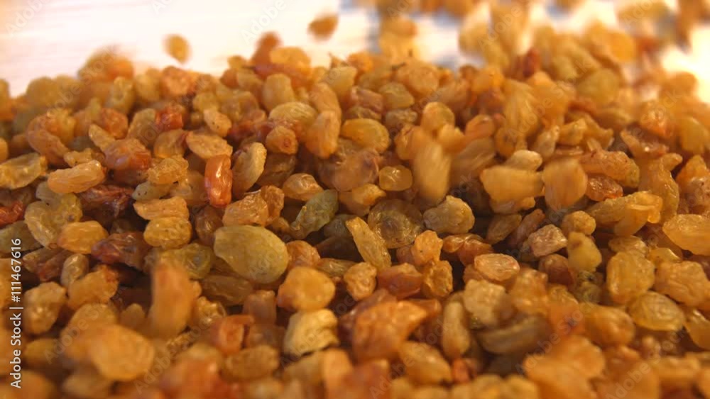 Raisins on a beige (texture table surface) background. 2 Shots.Vertical pan. Close-up. Raisins on a beige (texture table surface) background. 2 Shots.Vertical pan. Close-up.