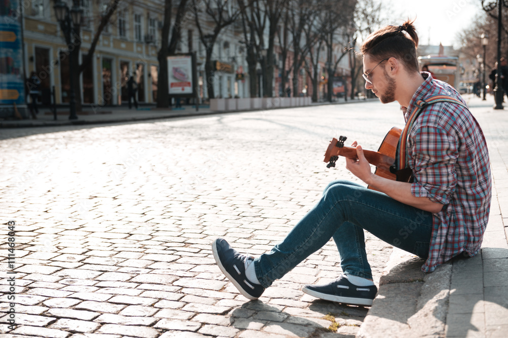 Man playing on the guitar outdoors
