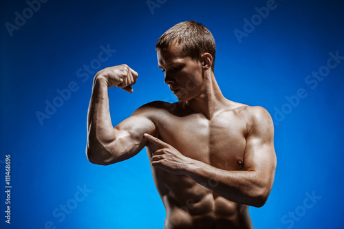 Fit young man with beautiful torso on blue background