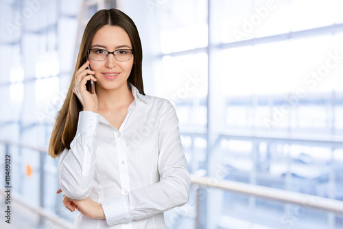 Young, confident, successful and beautiful business woman with the mobile phone isolated