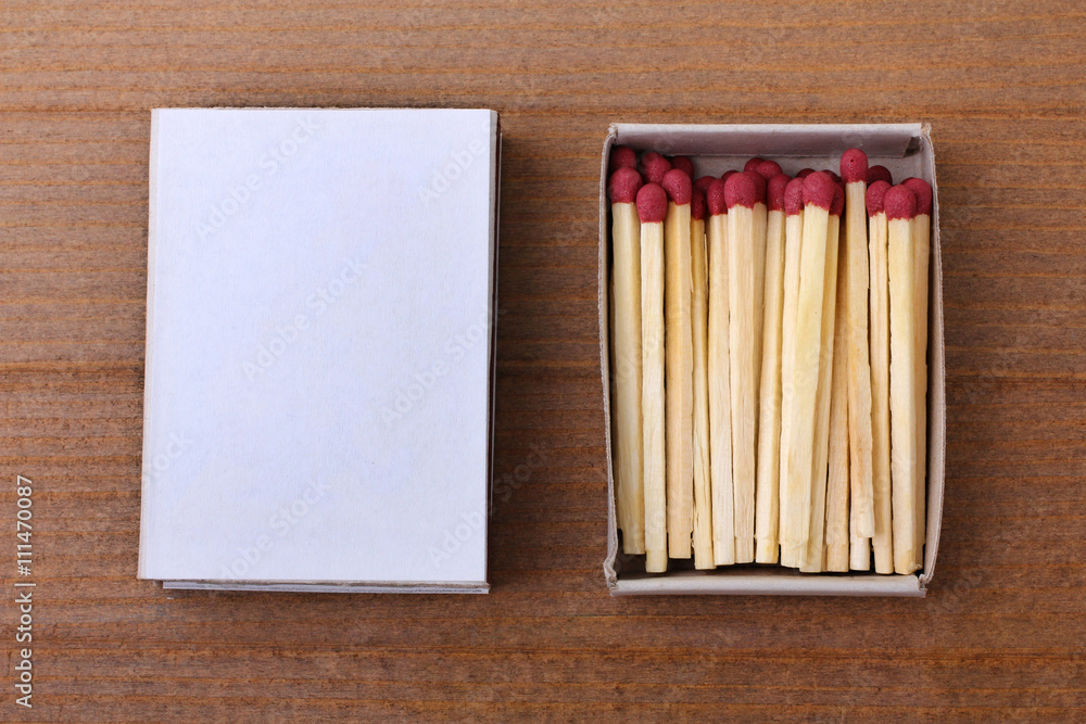 matchbox with matches on a brown wooden table matchbox with matches on a brown wooden table