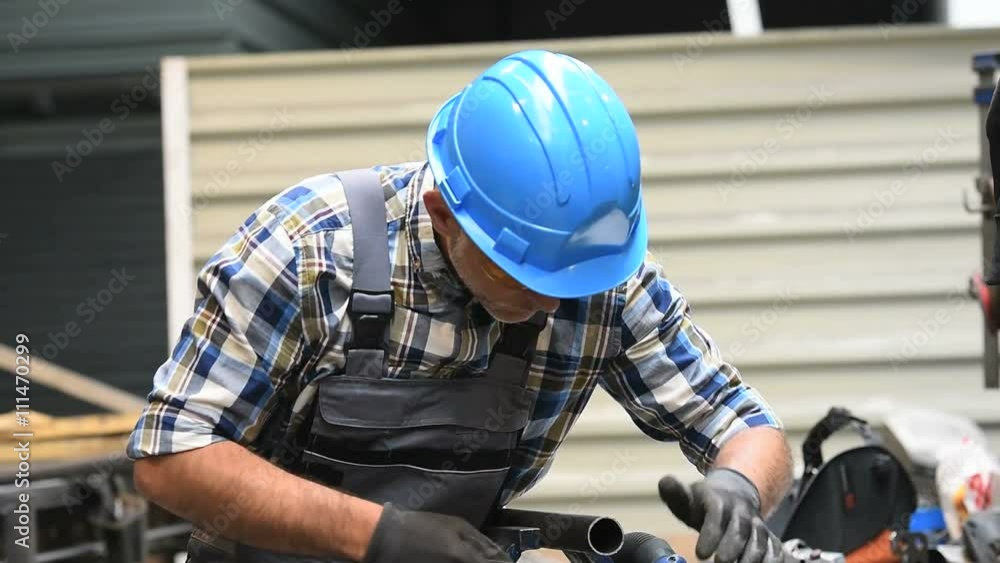 Metalworker with hardhat working piece of metal Metalworker with hardhat working piece of metal