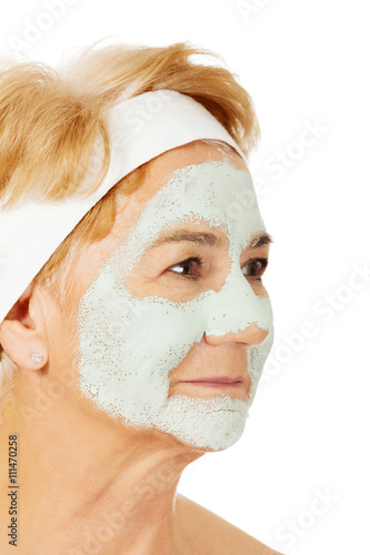 Relaxed elderly woman in facial mask