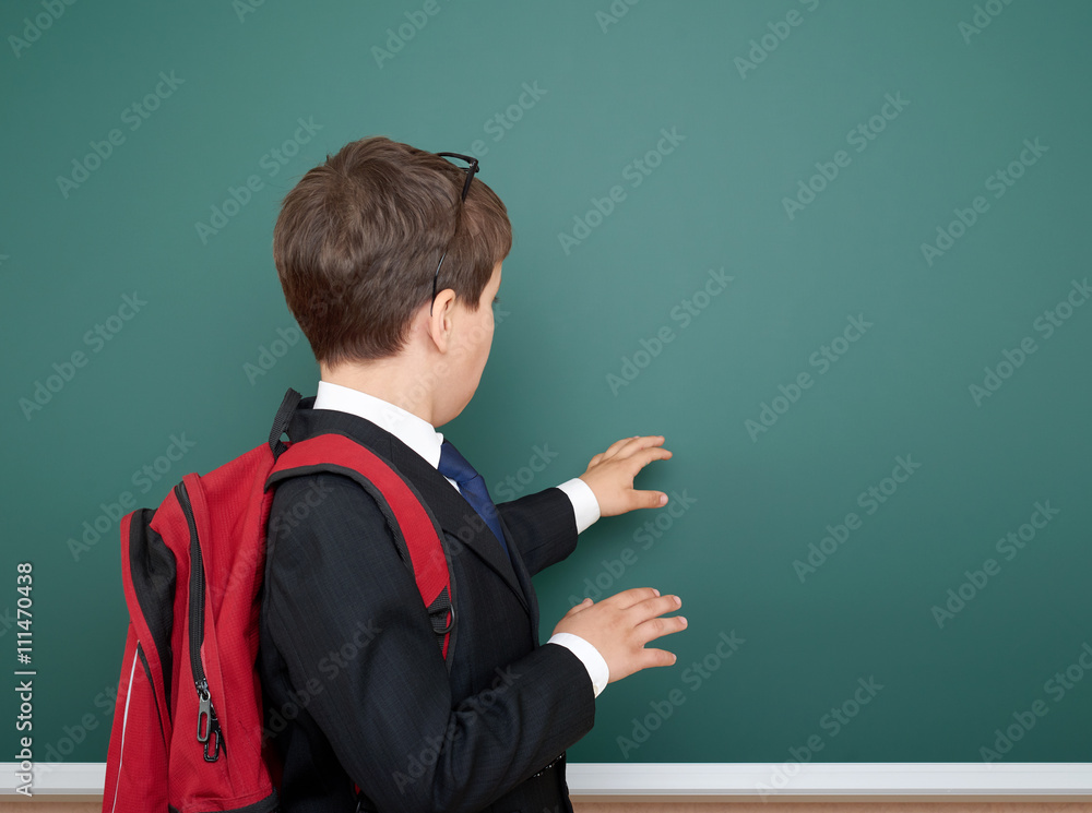 school boy portrait in black suit on green chalkboard background with red backpack, education concept school boy portrait in black suit on green chalkboard background with red backpack, education concept