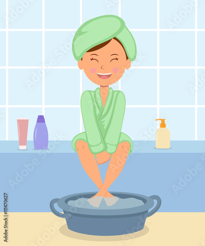Young girl taking Spa treatments. Female in the bathrobe keeps feet in hot water before a pedicure.