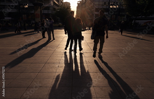 Shadows of people walking in a street of the city at the sunset, Athens, Greece.