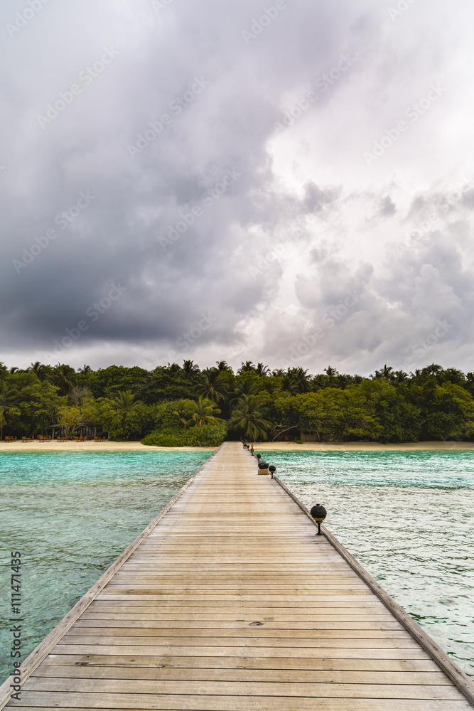 jetty to a little tropical island in the turquoise indian ocean, maldives, way to a travel destination