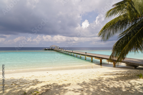 jetty to a little tropical island in the turquoise indian ocean  maldives  way to a travel destination