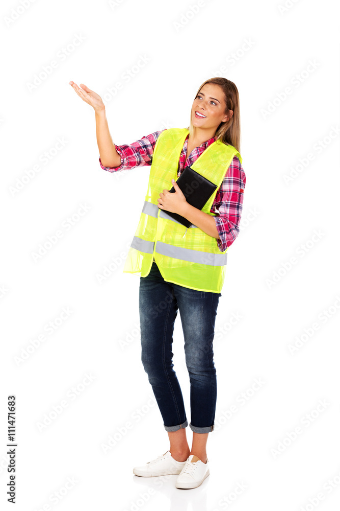 Female builder in a helmet and a vest with a notebook Female builder in a helmet and a vest with a notebook