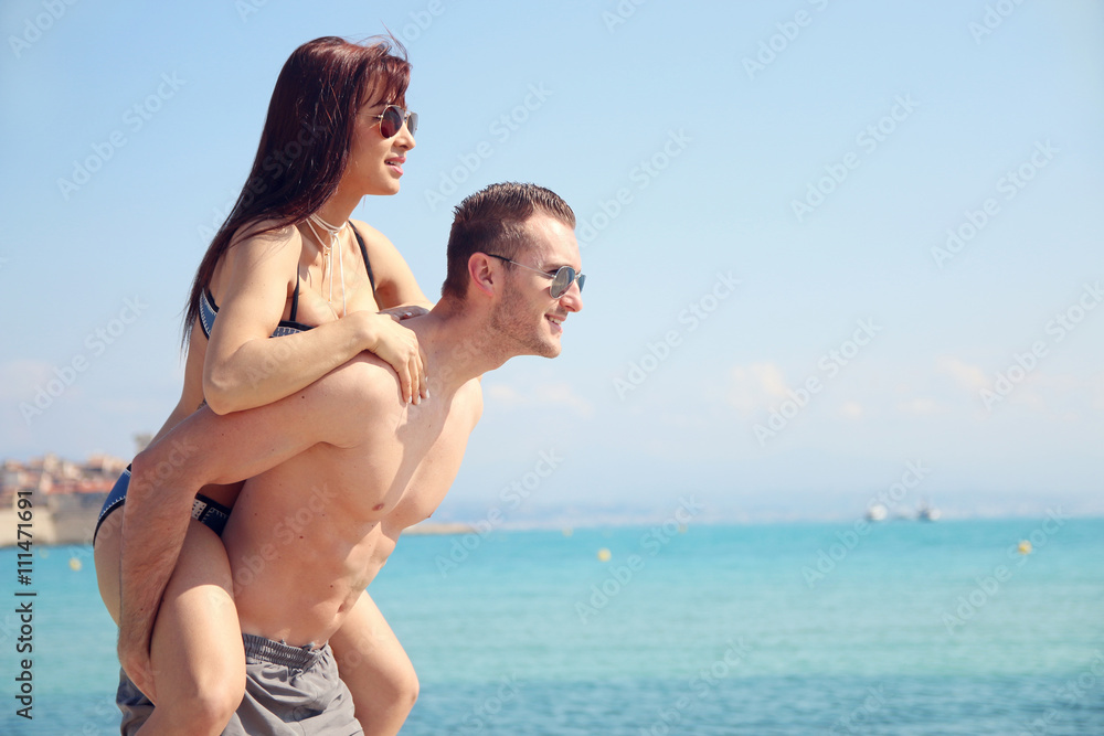 summert love - young woman on the back of her boyfriend summert love - young woman on the back of her boyfriend