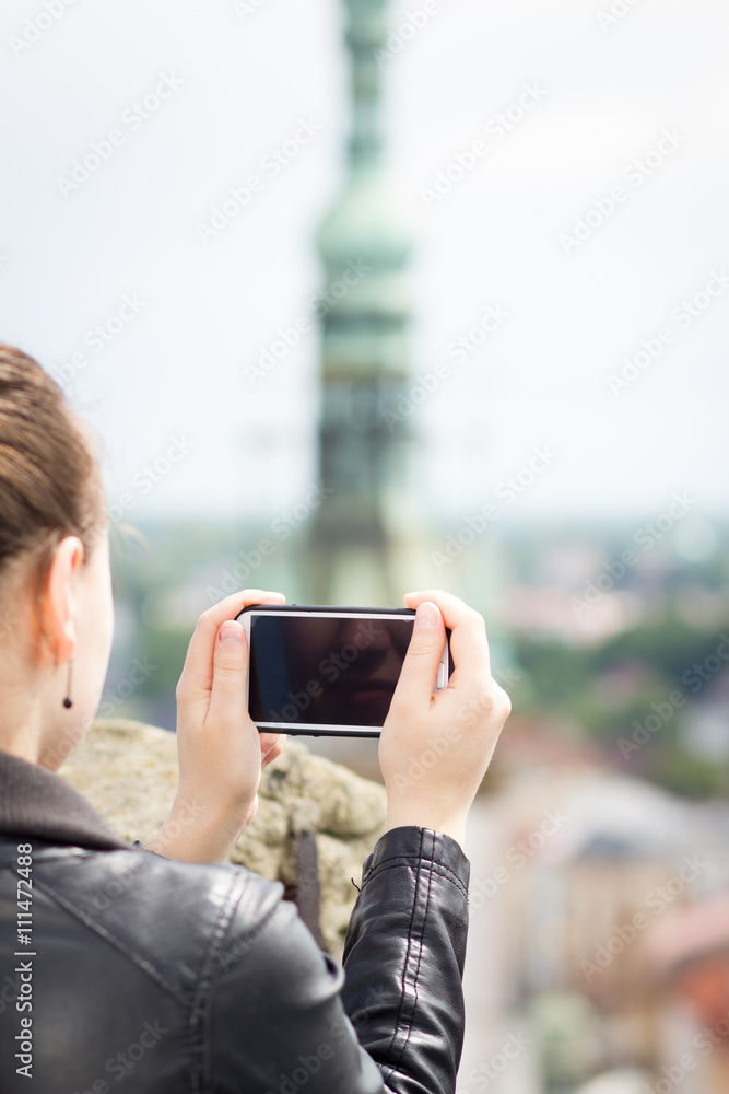 Young woman / girl / lady shooting / taking a photo of huge / bi