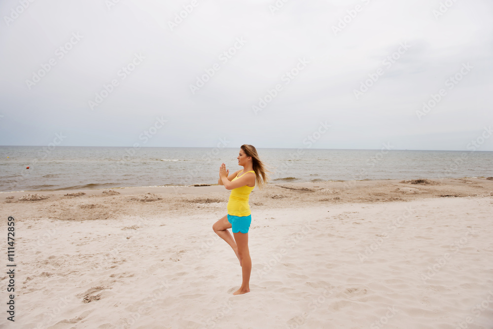 Young woman making yoga exercises on the beach Young woman making yoga exercises on the beach