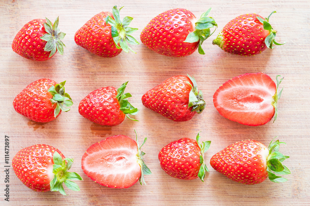 Strawberries on a wooden table. Arranged in a order. Strawberries on a wooden table. Arranged in a order.