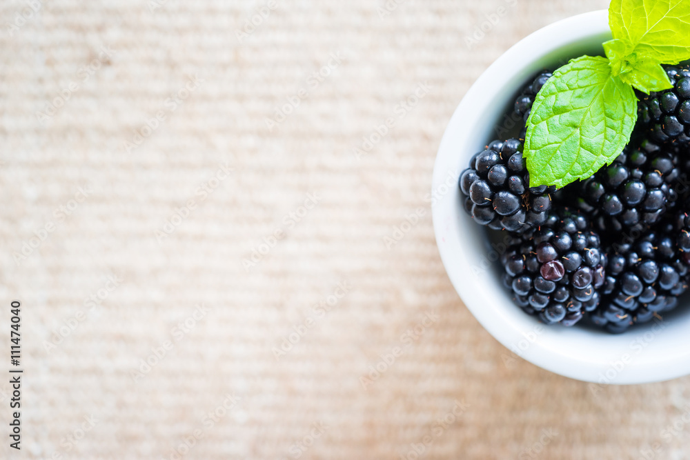 Top view of single cap filled with fresh blackberries and mint. Top view of single cap filled with fresh blackberries and mint.
