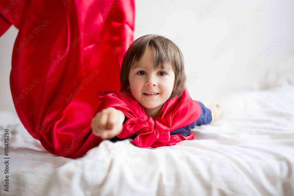 Sweet little preschool boy, playing superhero at home Sweet little preschool boy, playing superhero at home