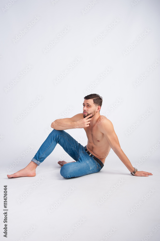 Fototapeta premium Fashionable topless, unshaven guy sitting on the floor
