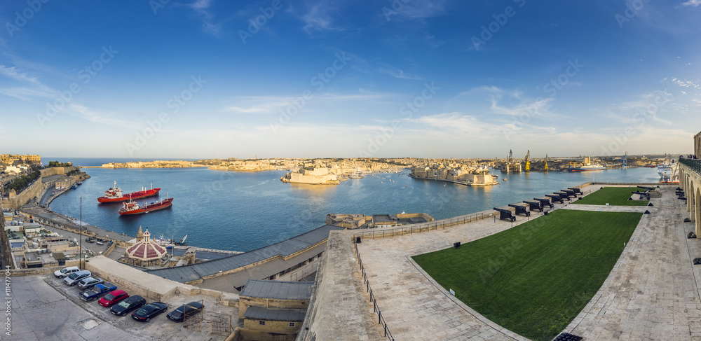 Valletta, Malta - Panoramic skyline view of the Grand Harbor of Valletta from Upper Barrakka Gardens at daylight with blue sky